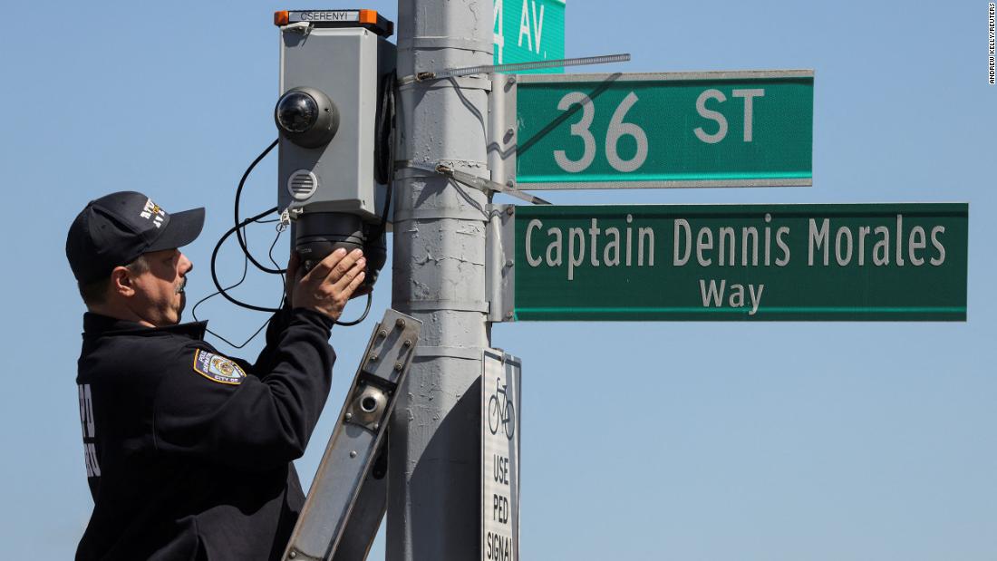 A New York City police officer checks security cameras near the scene.