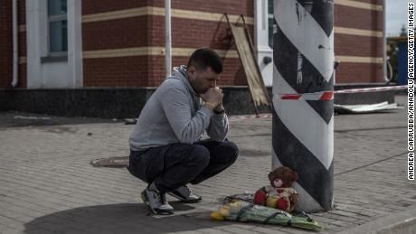 A man lays flowers at a memorial at Kramatorsk railway station.