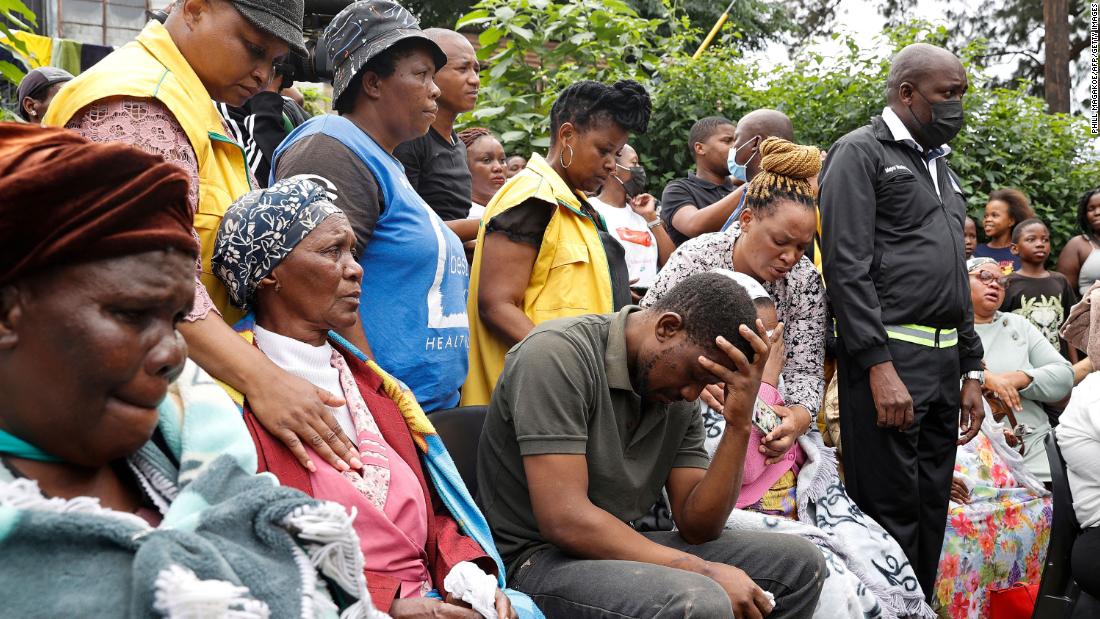 People grieve at a church in Clermont, a township in Durban, after four children died following heavy rains and floods. Mmeli Sokhela, center, lost four children when the church collapsed onto his home.
