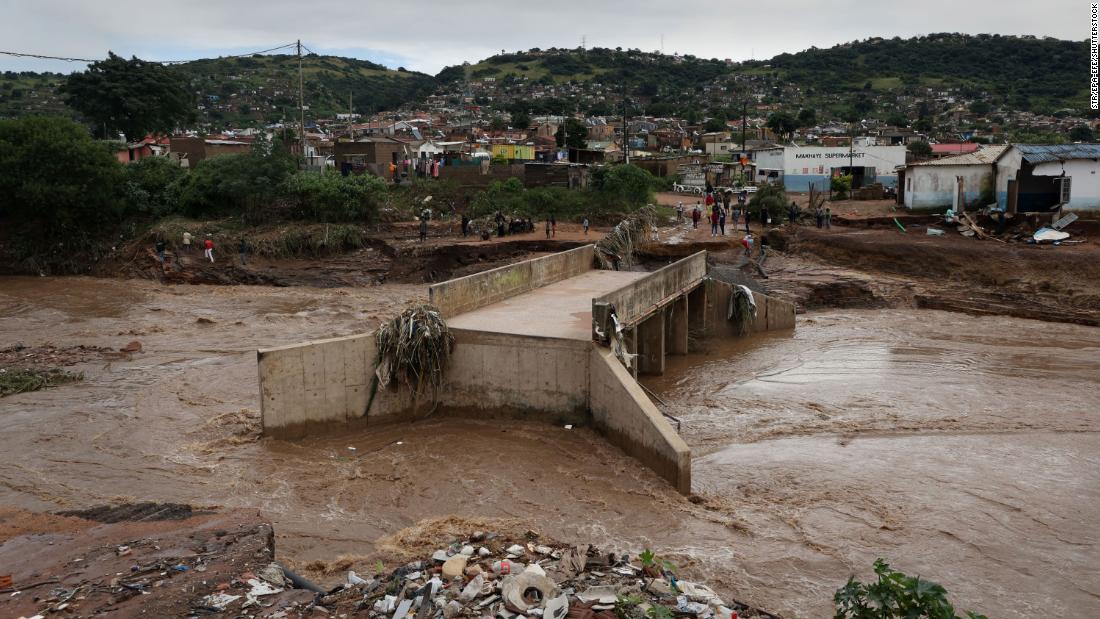 A river runs around a damaged bridge on April 12 after heavy rains destroyed it near Durban.