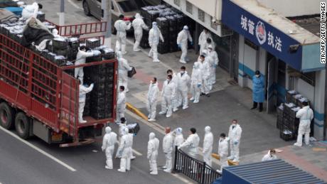 Workers in hazmat suits transport daily food supplies and necessities for local residents during the Covid-19 lockdown in Shanghai.