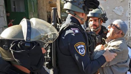 Israeli security forces quarrel with a Palestinian man as he tries to enter the al-Aqsa mosque to attend Friday prayers on April 15, 2022. 