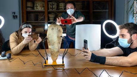 (From left) Carol Anne Barsody, Van Hunter Adams, and Jack Defay photograph a mummified bird to create a 3D rendering of the artifact on February 24 at Cornell University in Ithaca, New York.