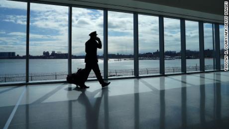A pilot walks past the windows at the newly renovated Delta terminal D at LaGuardia Airport in New York March 6, 2021.