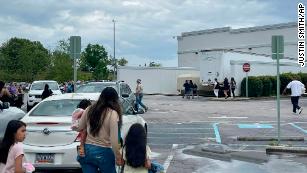 Pessoas andam por um estacionamento no shopping Columbiana Center em Columbia, SC, no sábado, 16 de abril de 2022, enquanto a polícia investiga um tiroteio no shopping.