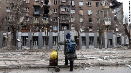 A local resident looks at a damaged apartment building near the Illich metallurgical plant in Mariupol on Saturday, April 16, 2022. 