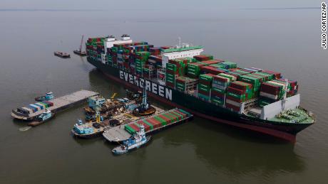 Barges are seen near the container ship Ever Forward, right, which ran aground last month, as workers remove containers from it in efforts to lighten the load and refloat the vessel, Wednesday, April 13, 2022, in Pasadena, Md.