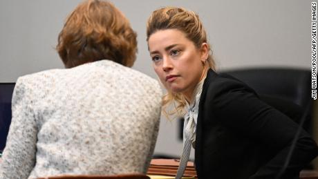 Amber Heard speaks with one of her attorneys at the Fairfax County Circuit Courthouse on April 19th.