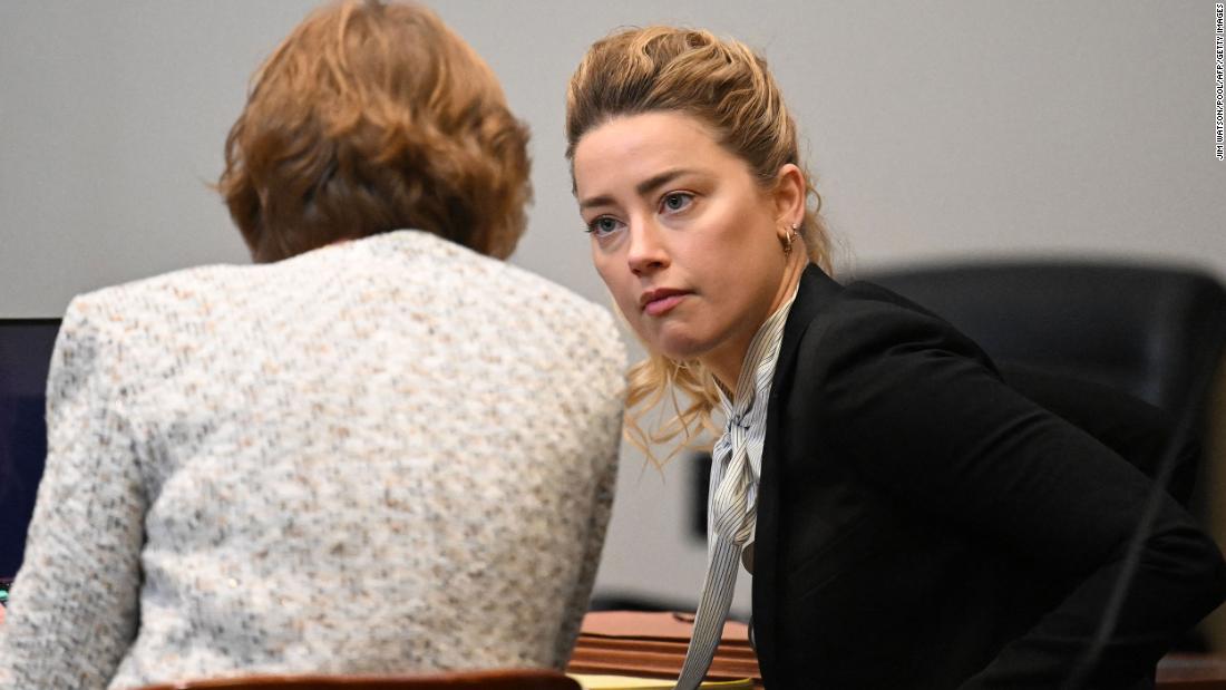 Amber Heard speaks to her attorney at the Fairfax County Circuit Courthouse in Fairfax, Virginia on Tuesday.