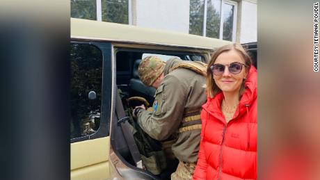Poudel stands next to a Ukrainian soldier picking up supplies she helped to supply to her father and his unit.