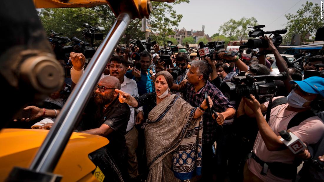Communist Party of India leader Brinda Karat, center, stands in front of a bulldozer during the demolition of Muslim-owned shops in New Delhi&#39;s northwest Jahangirpuri neighborhood, in New Delhi, India, Wednesday, April 20, 2022. 