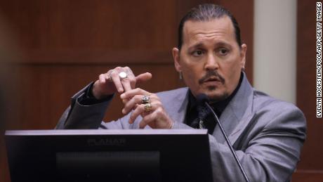 Johnny Depp points the middle finger at his hand in court, injured in 2015.