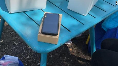 A government-issued cell phone sits on a table in a park where recently released migrants have been gathering in San Antonio, Texas.