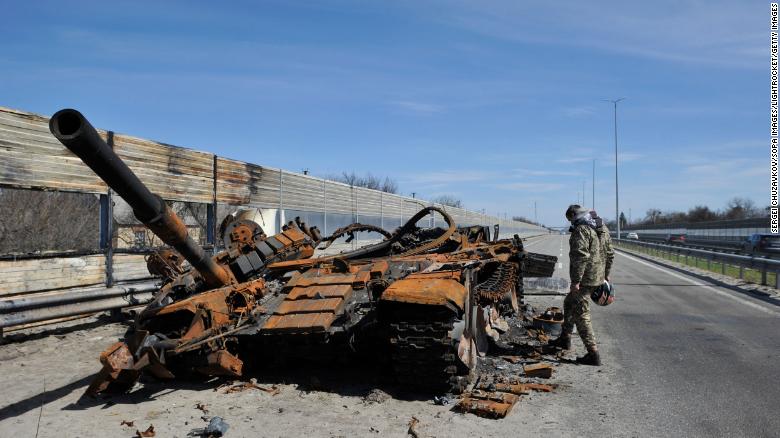 A man inspects destroyed tank of the Russian army about 40 kilometers west of Kyiv, the Ukraine capital. 