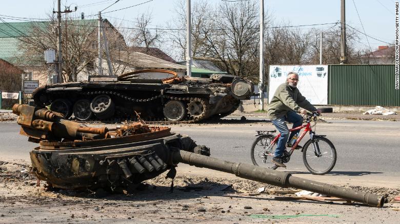 A man rides a bike near a destroyed Russian tank near Brovary, near Kyiv, Ukraine, on April 15.