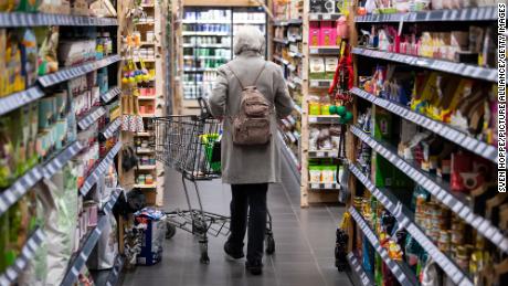 A woman walks past a supermarket with her cart on March 31, 2022, in Neubiberg, Bavaria.