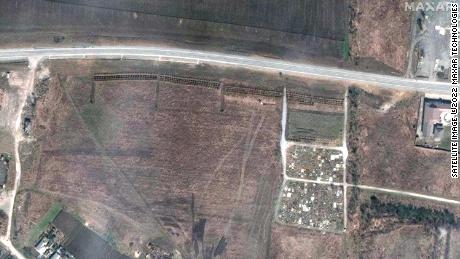 A satellite image from  April 3 shows what appears to be a newly dug mass grave site, next to the cemetery. 