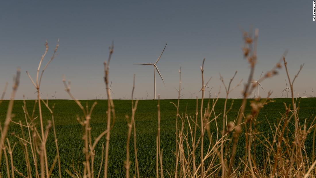 A wind turbine spins over a wheat field in Weatherford.
