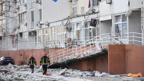 Firefighters walk past an apartment building damaged by Russian shelling in Odesa, Ukraine, Saturday, April 23, 2022. Ukrainian officials reported that Russia fired at least six cruise missiles at the Black Sea port city of Odesa, killing five people. (AP Photo/Max Pshybyshevsky)