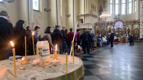 The faithful wait their turn to kneel and pray before the church altar on Saturday.