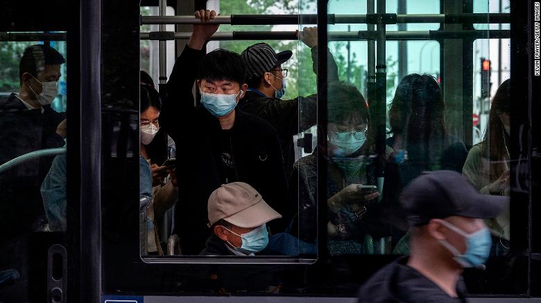 People wear protective masks as they ride on a public bus during evening rush hour  in the Central Business District on April 21, 2022 in Beijing, China.