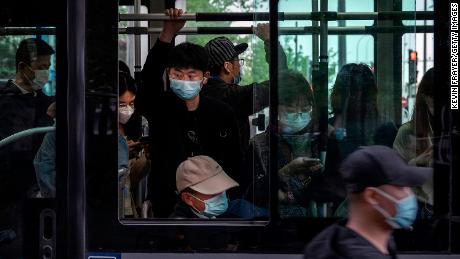 People wear protective masks as they ride on a public bus during evening rush hour  in the Central Business District on April 21, 2022 in Beijing, China.