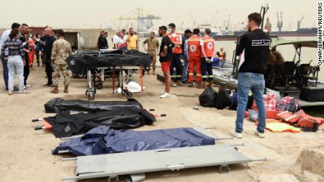 Emergency services workers and stretchers stand ready on April 24, 2022, after a boat capsized off the coast of Tripoli, Lebanon, overnight.