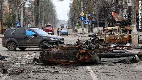 Part of a destroyed tank and a burnt car are photographed in an area controlled by Russian-backed separatist forces in Mariupol on April 23.