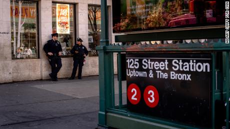 Police officers stand outside of Harlem&#39;s 125 Street Station.