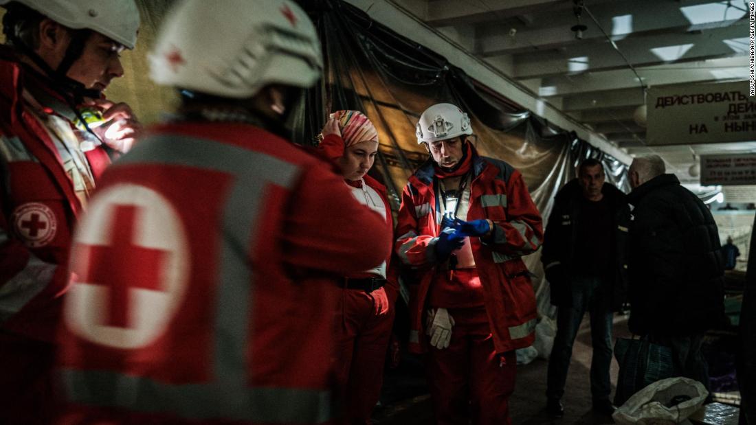 Members of the Ukrainian Red Cross talk before moving an elderly woman to an ambulance in a bunker under a factory in Severodonetsk, Ukraine, on April 22.