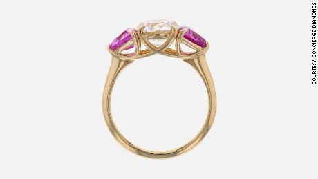 This engagement ring from Concierge Diamonds has a 1 ct lab grown diamond with 2 pink sapphires in a 14k yellow gold band.  (Prices start at $3,500 depending on center diamond)