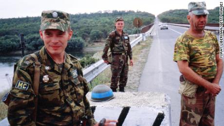 Un oficial ruso (izquierda), un soldado moldavo (centro) y un soldado de Transnistria (derecha) montan guardia en la zona de seguridad que separa Moldavia y Transnistria a lo largo del río Dniéster, en 2002.