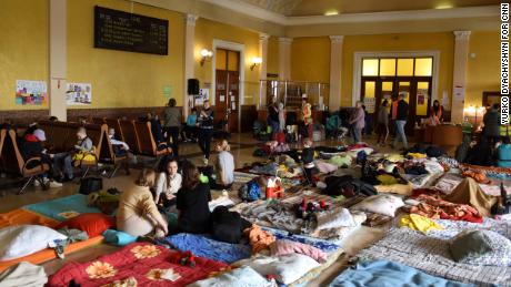 Women and children rest on wooden benches and mattresses in a room above Lviv train station. One corner has been converted into a children&#39;s play area, with toys, books and games.