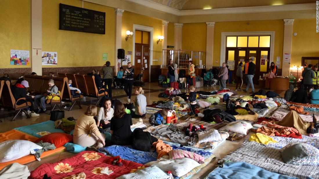 Жінки та діти відпочивають на дерев'яних лавках і матрацах у кімнаті над львівським вокзалом.  Один куточок був перетворений на дитячу ігрову зону з іграшками, книжками та іграми.