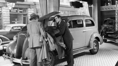 By the mid-20th century, car dealers had real political clout, helping to pass laws protecting their independent businesses from infringement by major automakers.  Here, a salesman shows off the engine of a 1937 Chevrolet Master.