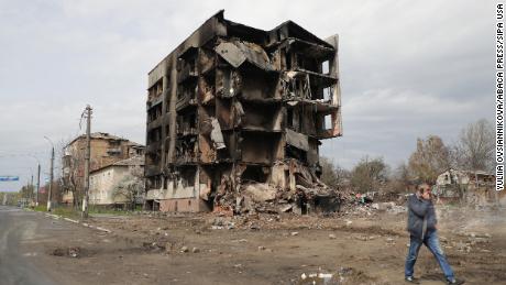 A man talking on the phone walks past the ruins of an apartment block destroyed as a result of Russian shelling in Borodianka, an urban-type settlement liberated from Russian invaders, Kyiv Region, northern Ukraine, on April 25, 2022. 