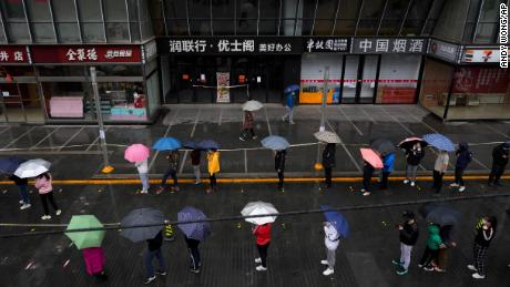 Locked-down residents line up in the rain for Covid tests in Beijing on April 27.