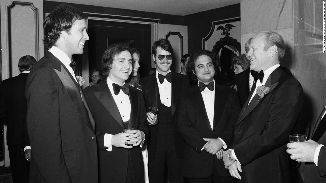 President Gerald Ford, right, speaks with comedian Chevy Chase, left, in 1976. Chase famously portrayed Ford as clumsy on &quot;Saturday Night Live.&quot; Between the two, from left, are &quot;Saturday Night Live&quot; creator Lorne Michaels and cast members Dan Aykroyd and John Belushi.