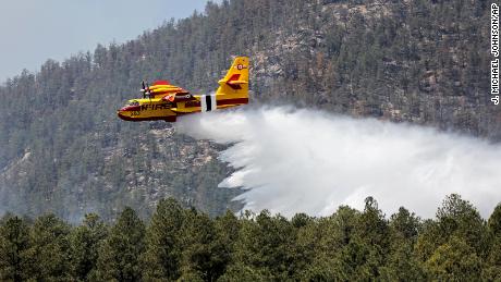 In this photo released by the US Forest Service, an aircraft known as a "super scooper" battles the Hermits Peak and Calf Canyon Fires in the Santa Fe National Forest in New Mexico on Thursday, April 28, 2022. 