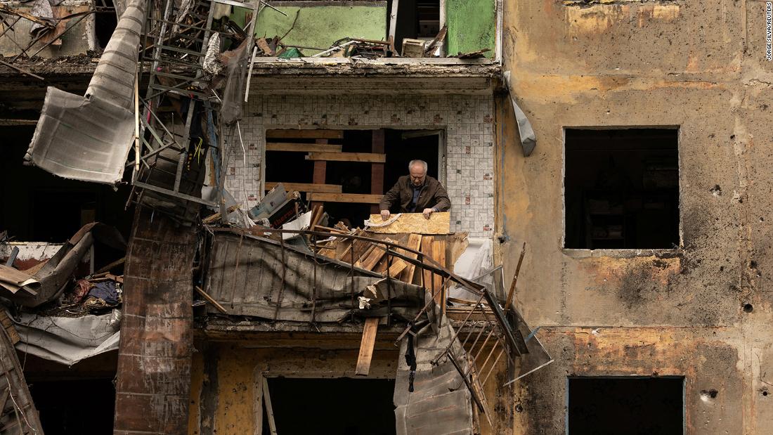 A man stands on the balcony of his apartment after a missile strike damaged a residential building in Ukraine&#39;s Donetsk region on April 30.