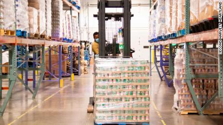 A Second Harvest Heartland staffer moves a pallet of canned goods in the food bank&#39;s warehouse in Brooklyn Park, Minnesota.
