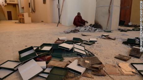 Mannen vinden op 29 januari 2013 verbrande oude manuscripten terug in het Ahmed Baba Centrum voor Documentatie en Onderzoek in Timboektoe. 