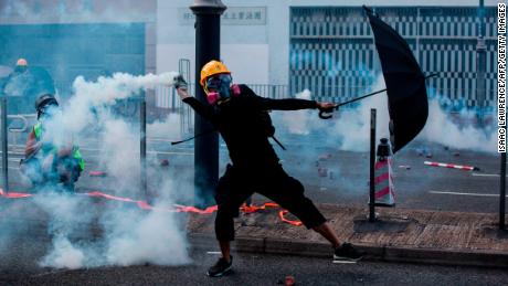 A protester throws back a tear gas canister fired by police in Hong Kong on October 1, 2019.
