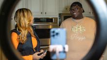 Khamyra Sykes and Robert Dean work on a TikTok video together in the home&#39;s kitchen.