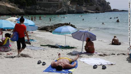 Dermatologists say sunscreen should be reapplied every two hours after spending time outdoors or in water. Beachgoers cool off at Cala Major in Palma de Mallorca, Spain, on August 14, 2021. 