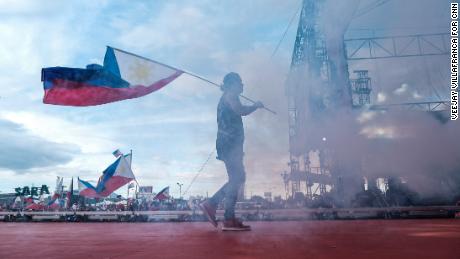 A performer holds the Philippines flag during a campaign sortie in an open parking lot in San Fernando City, Pampanga, on April 29.