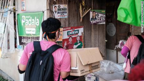 Volunteers carrying paraphernalia conduct a house-to-house campaign for Vice President Leni Robredo&#39;s presidential bid in Antipolo City, Philippines, on April 27.