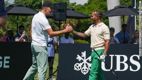 Tom Brady and Lewis Hamilton shake hands at the Big Pilot Charity Challenge at Miami Beach Golf Club, in Miami Beach, Florida on May 4, 2022.