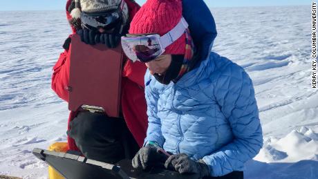 Het team controleert gegevens van een magnetisch station waarmee ze de bodem van de ijskap in kaart hebben gebracht.