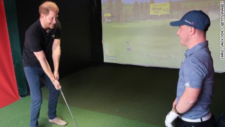 Pangeran Harry mendapat pelajaran golf dari Lawlor.